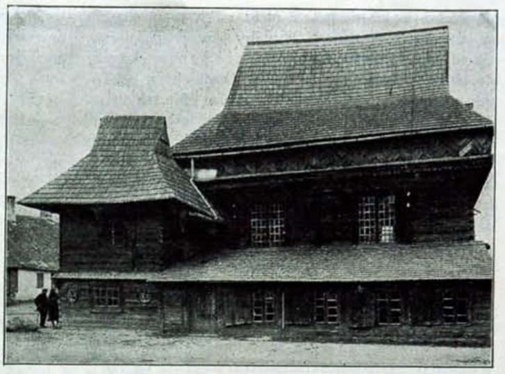 Black-and-white photograph of the long side of the synagogue with a lean-to lower storey, a tall main roof and a smaller pavilion roof at left.