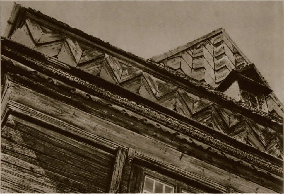 Sepia close-up of overlapping roof eaves decorated with carved zig-zag boards and moulded cornices.